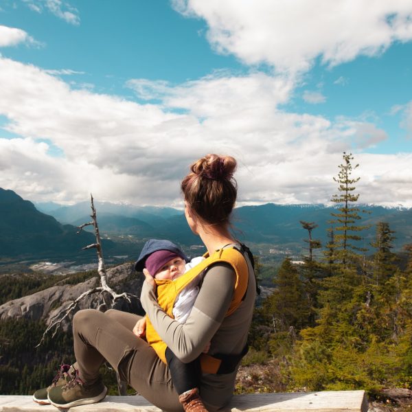 woman holding her baby while looking out over scenic view