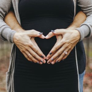 heart hands over pregnant stomach